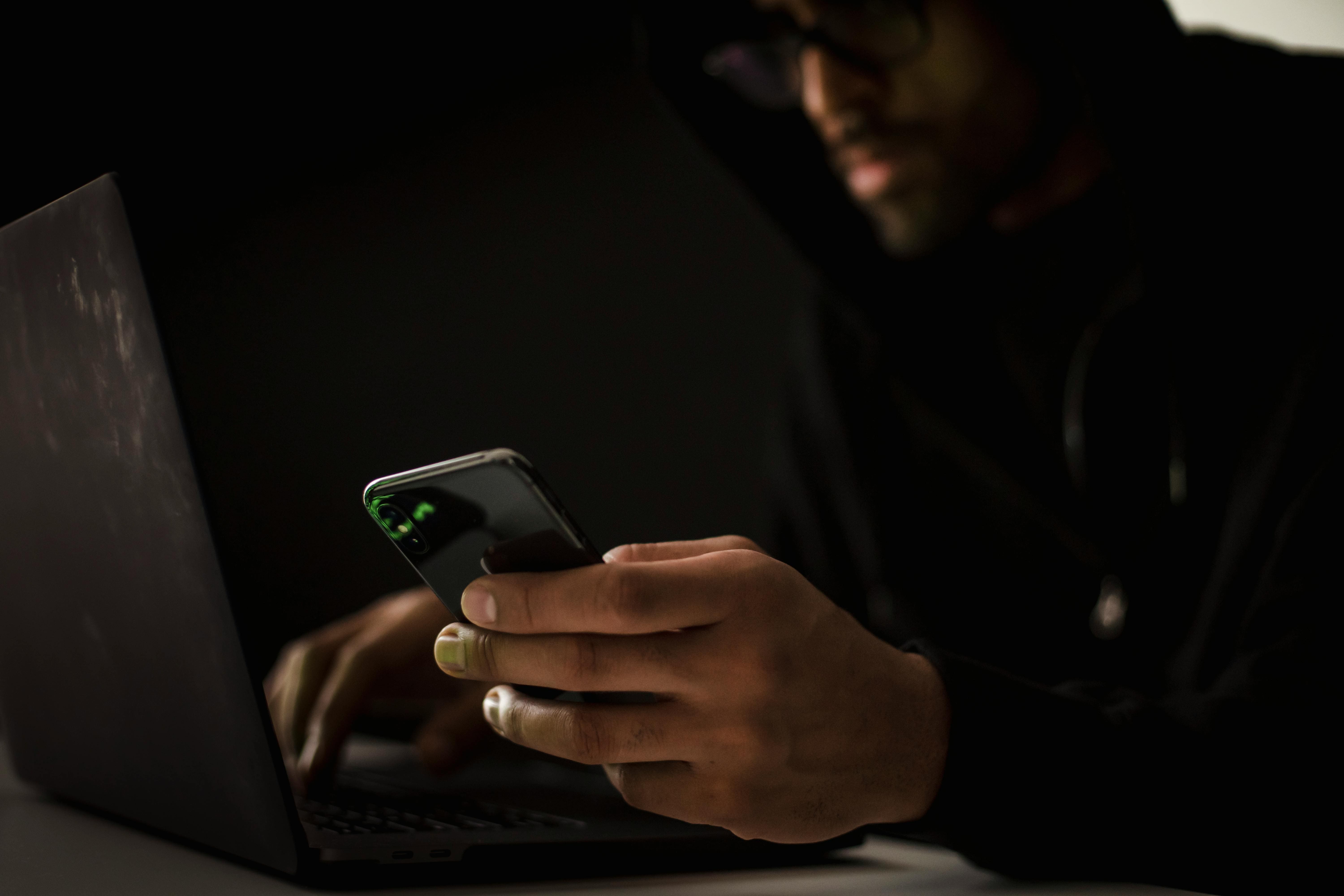 A person using a phone and laptop
